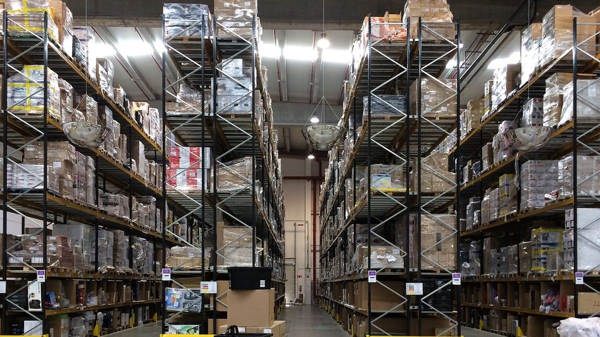 Kho hàng lớn với nhiều kệ cao chứa hộp carton đóng gói