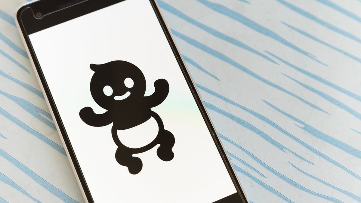 Điện thoại hiển thị hình minh hoạ nhân vật chatbot hoạt hình cười